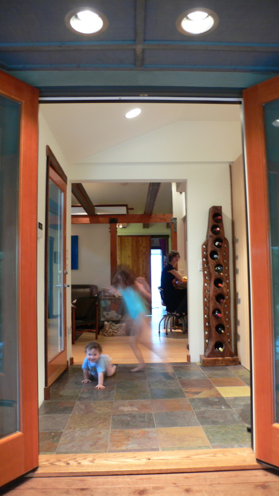 Kleines Maritimes Foyer mit weißer Wandfarbe, Schieferboden, Einzeltür und hellbrauner Holzhaustür in Los Angeles