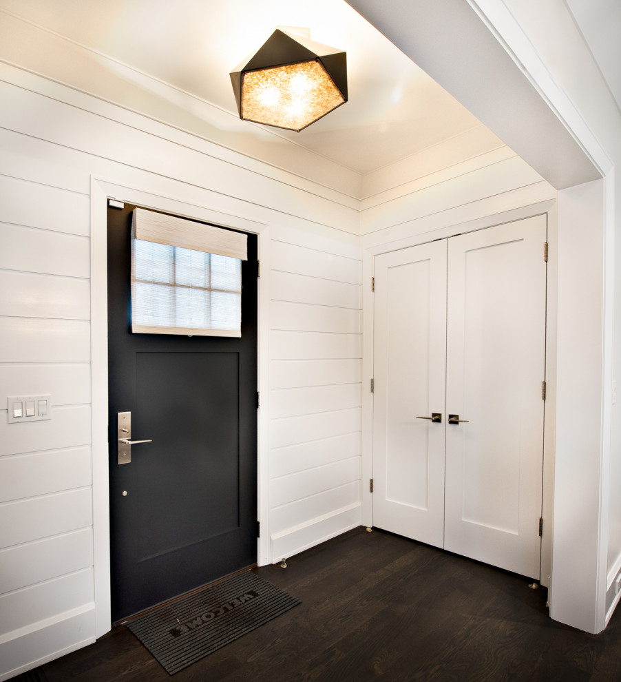 Свежая идея для дизайна: прихожая в современном стиле с белыми стенами, деревянным полом, одностворчатой входной дверью, коричневой входной дверью, коричневым полом и стенами из вагонки - отличное фото интерьера