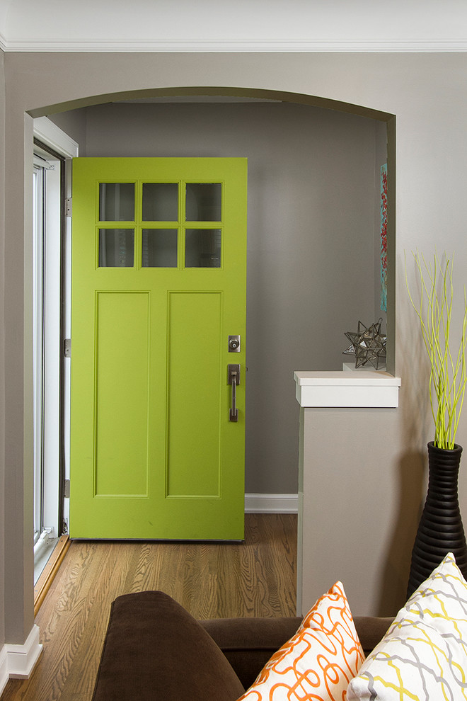 Réalisation d'une petite porte d'entrée tradition avec un mur gris, un sol en bois brun, une porte simple et une porte verte.