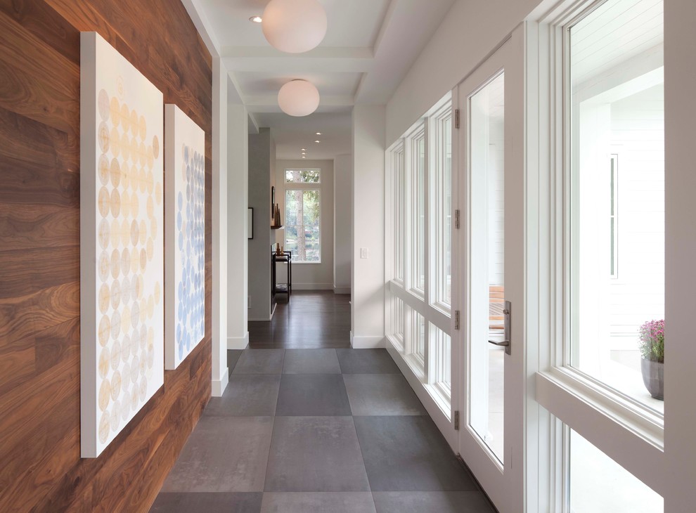 Contemporary hallway in Minneapolis with a glass front door, grey floors and a feature wall.