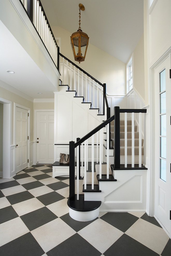 This is an example of a large traditional foyer in Minneapolis with beige walls, multi-coloured floors and feature lighting.