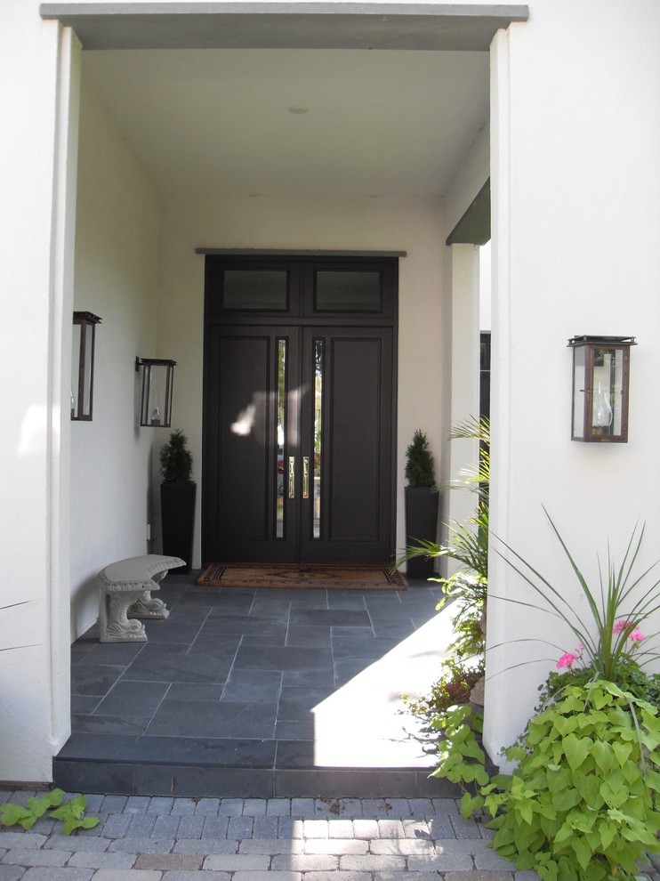 Idées déco pour une grande porte d'entrée moderne avec un mur blanc, un sol en ardoise, une porte double et une porte noire.