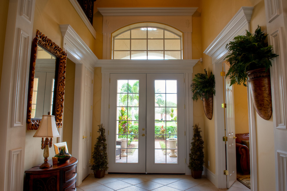 マイアミにあるお手頃価格の中くらいなトラディショナルスタイルのおしゃれな玄関ドア (黄色い壁、白いドア) の写真