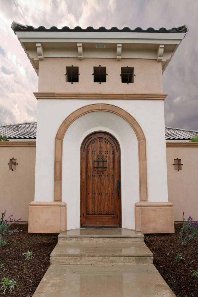 Inspiration pour une porte d'entrée méditerranéenne avec une porte simple et une porte en bois foncé.