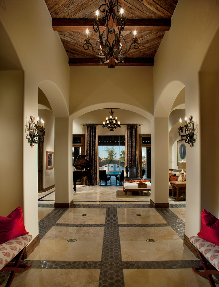 Großes Mediterranes Foyer mit beiger Wandfarbe, Travertin, Einzeltür und dunkler Holzhaustür in Phoenix