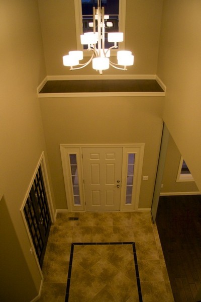 Elegant ceramic tile entryway photo in Other with beige walls and a white front door
