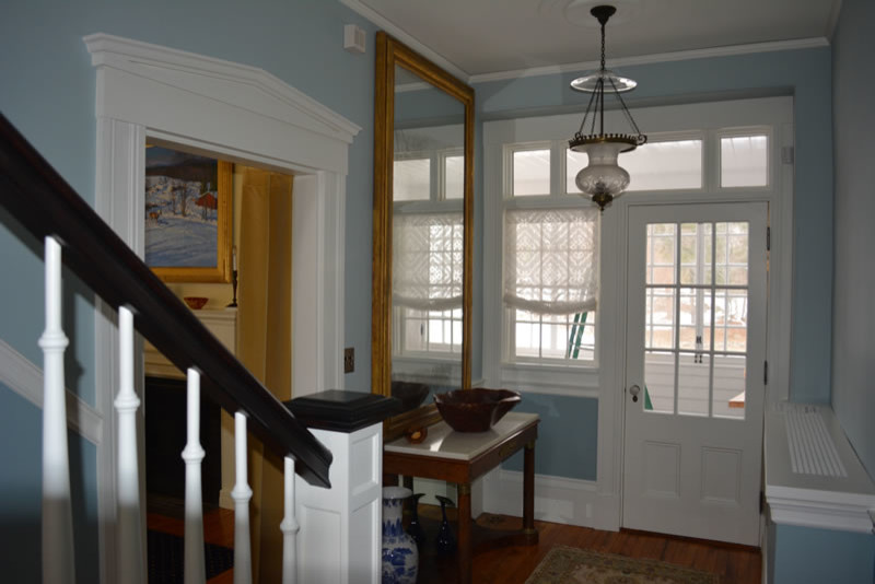 Mid-sized trendy medium tone wood floor entryway photo in Boston with gray walls and a white front door