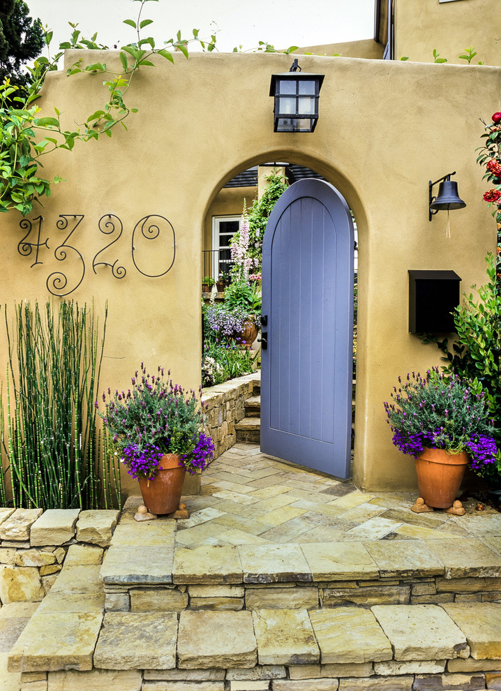 Стильный дизайн: входная дверь с бежевыми стенами, одностворчатой входной дверью и фиолетовой входной дверью - последний тренд