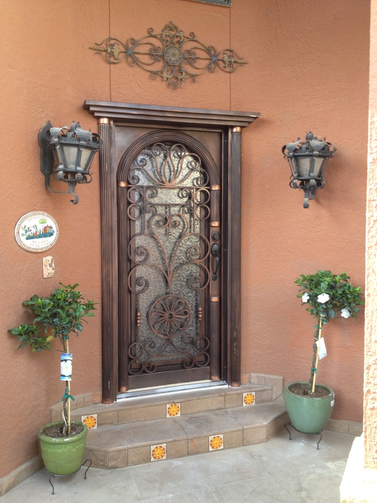 На фото: входная дверь среднего размера в классическом стиле с красными стенами, одностворчатой входной дверью и коричневой входной дверью