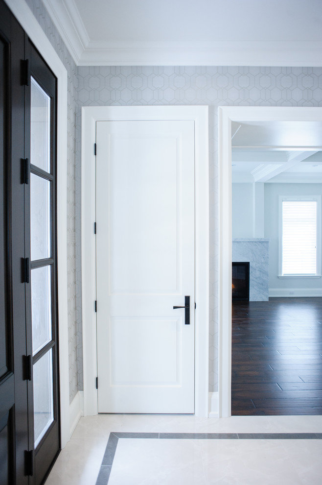 Foto di un ingresso minimal di medie dimensioni con pareti bianche, pavimento in marmo, una porta singola, una porta in legno scuro e pavimento marrone