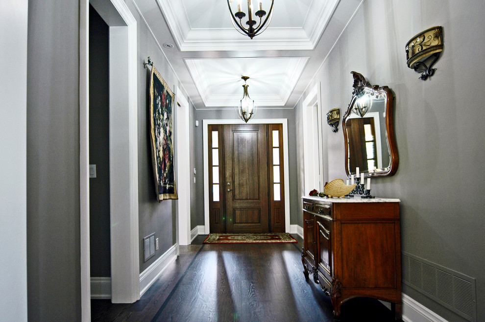 トロントにある中くらいなトラディショナルスタイルのおしゃれな玄関ロビー (グレーの壁、濃色無垢フローリング、濃色木目調のドア) の写真