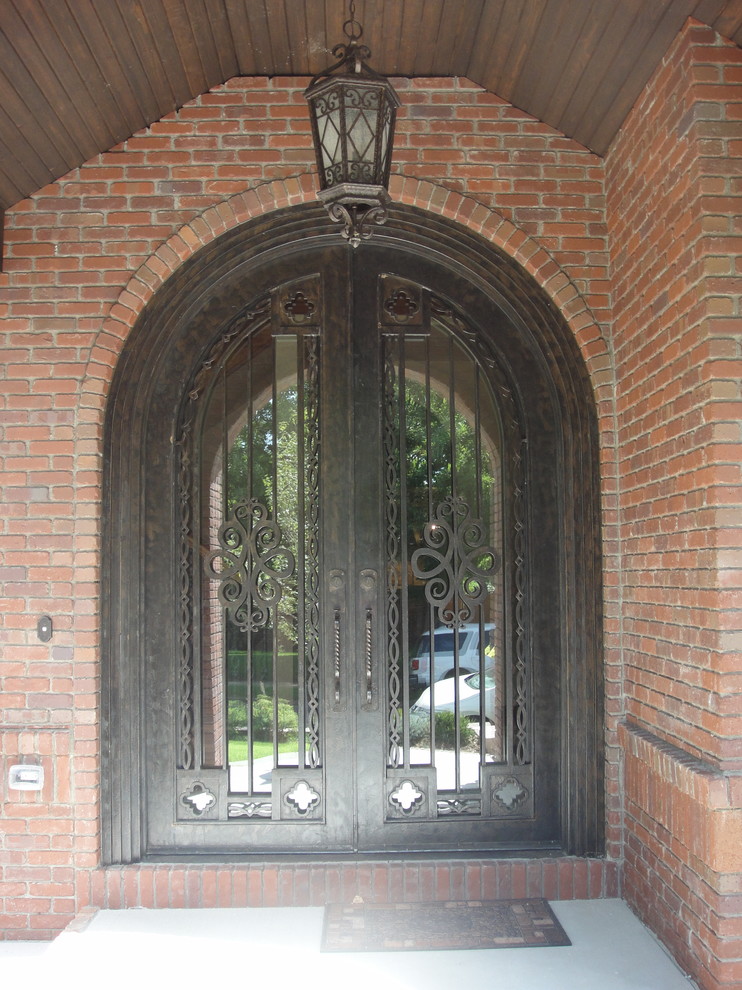 Ispirazione per una porta d'ingresso chic di medie dimensioni con pavimento in cemento, una porta a due ante e una porta in metallo