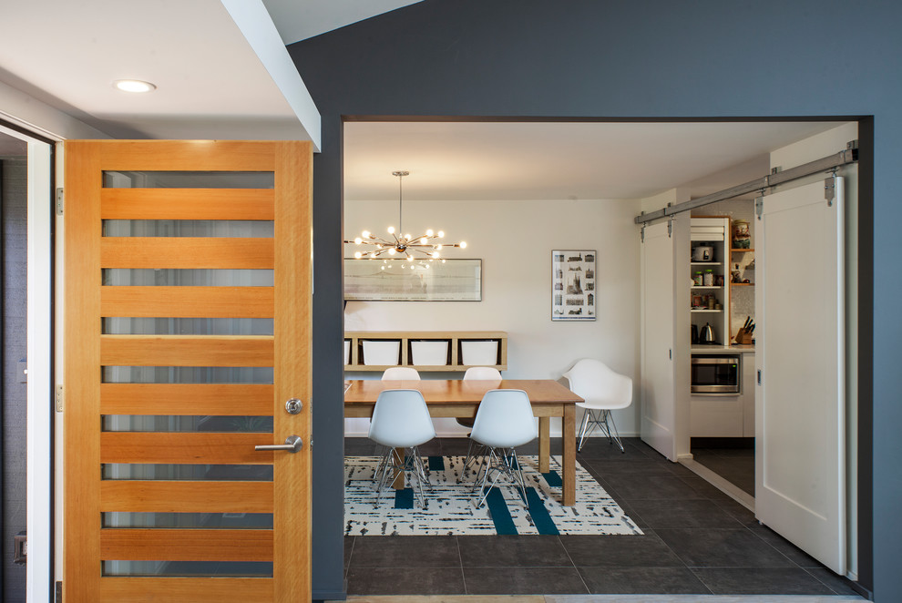 Idée de décoration pour un hall d'entrée vintage de taille moyenne avec un mur bleu, une porte en bois clair et un sol gris.