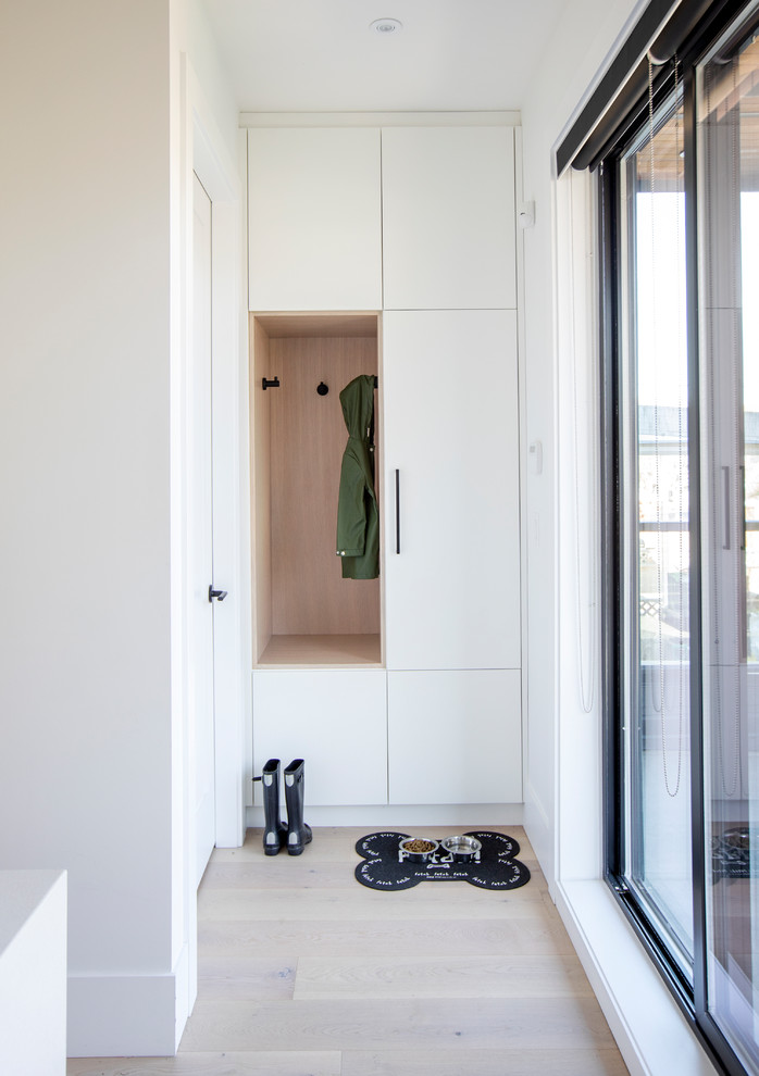 На фото: тамбур со шкафом для обуви в современном стиле с белыми стенами, светлым паркетным полом и бежевым полом с