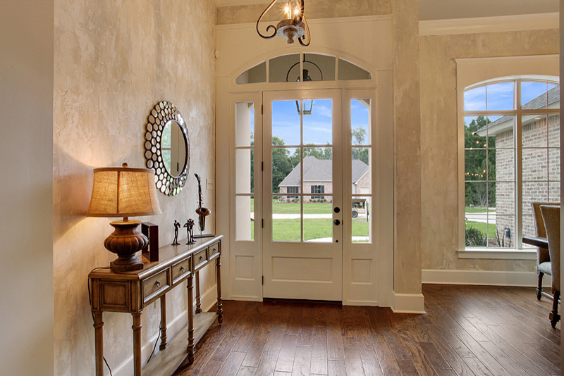 Landhausstil Foyer mit beiger Wandfarbe, dunklem Holzboden, Einzeltür, weißer Haustür und braunem Boden in New Orleans