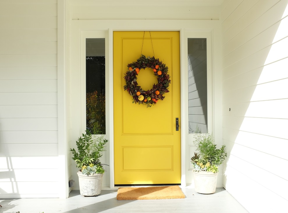 Idéer för en modern entré, med vita väggar, en enkeldörr och en gul dörr