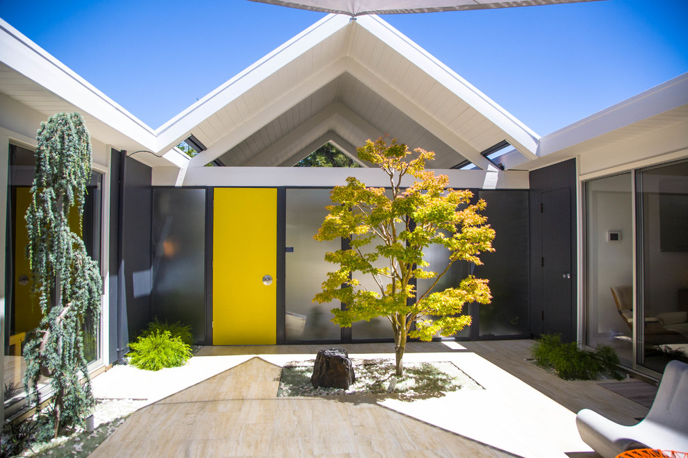 Esempio di una porta d'ingresso minimalista con pareti grigie, una porta singola, una porta gialla e pavimento beige