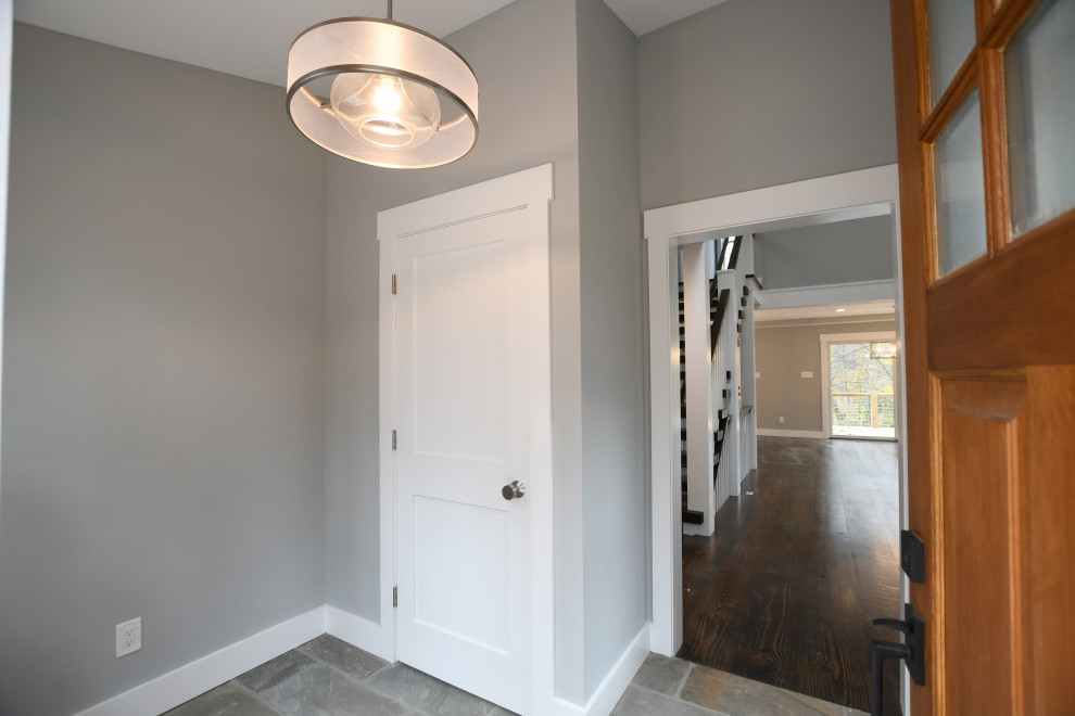 Пример оригинального дизайна: тамбур среднего размера в стиле кантри с серыми стенами, полом из сланца, одностворчатой входной дверью, коричневой входной дверью и серым полом