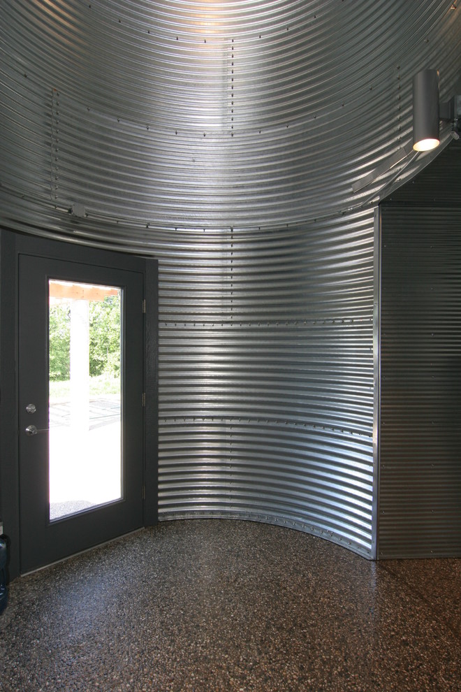 Exempel på en mellanstor industriell farstu, med metallisk väggfärg och betonggolv