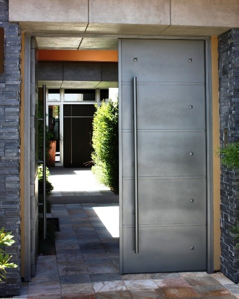 Bild på en stor funkis ingång och ytterdörr, med grå väggar, marmorgolv, en dubbeldörr och en grå dörr