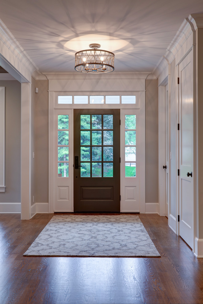 Mittelgroßes Klassisches Foyer mit grauer Wandfarbe, braunem Holzboden, Einzeltür, dunkler Holzhaustür und braunem Boden in Boston