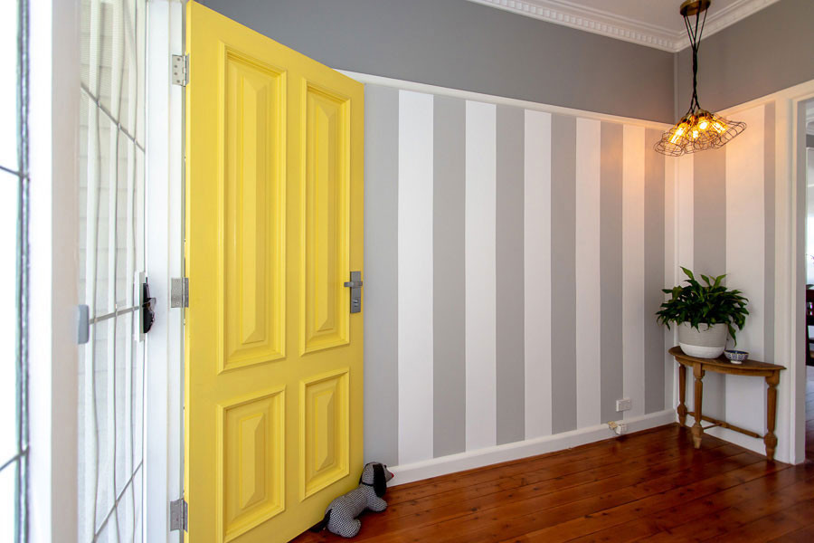 Ispirazione per un grande ingresso classico con pavimento in legno massello medio, una porta singola, una porta gialla e pavimento marrone