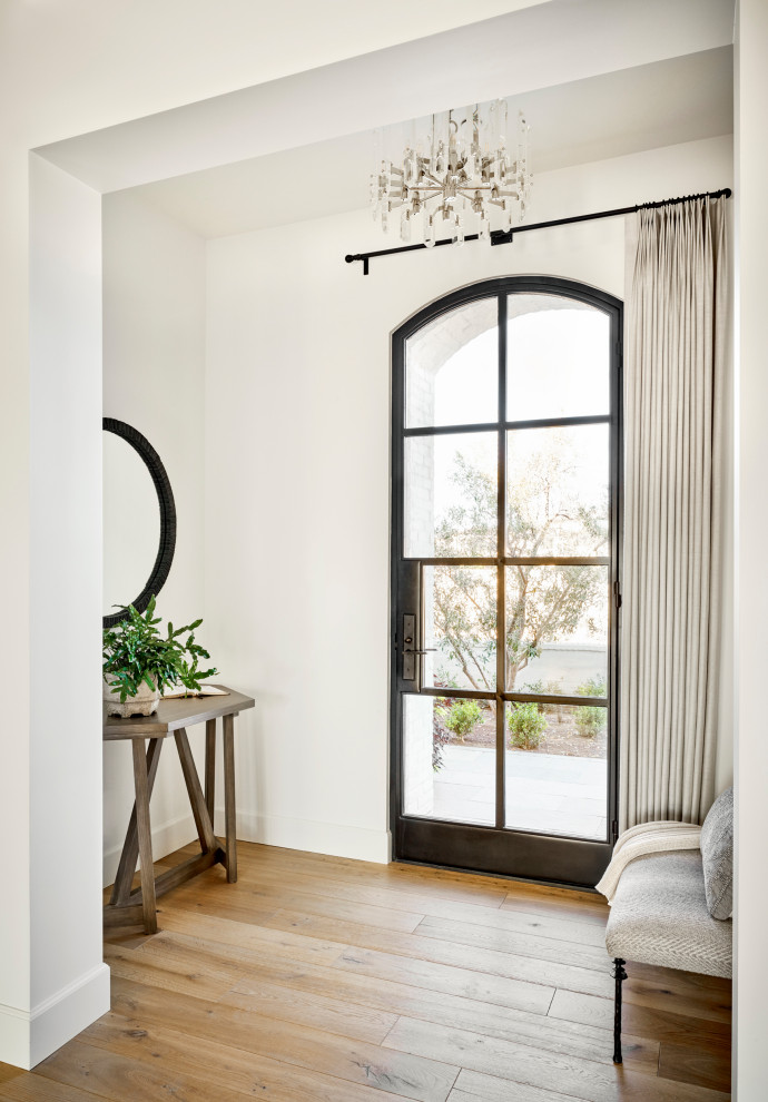 Idee per un grande corridoio tradizionale con pareti bianche, pavimento in legno massello medio, una porta singola, una porta nera e pavimento marrone
