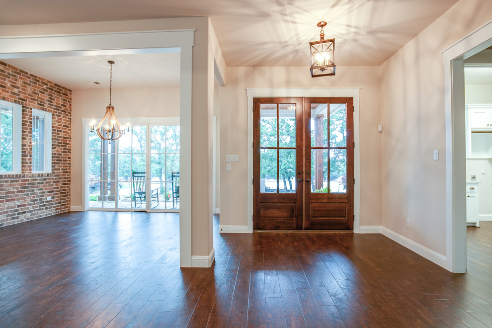 Photo of a large country foyer in Dallas with beige walls, medium hardwood flooring, a double front door, a glass front door and brown floors.
