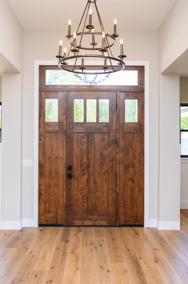 Ejemplo de puerta principal campestre pequeña con paredes beige, puerta simple, puerta de madera oscura, suelo de madera clara y suelo beige