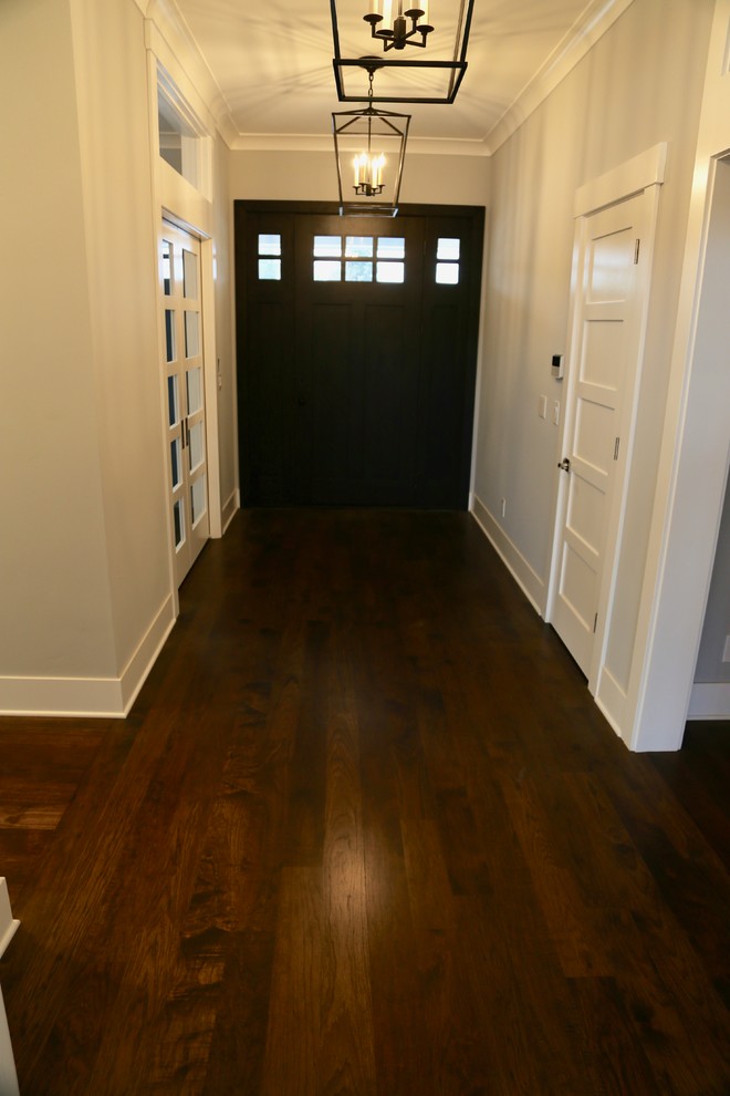 Idées déco pour un hall d'entrée craftsman avec un mur gris, parquet foncé, une porte simple, une porte en bois foncé et un sol marron.