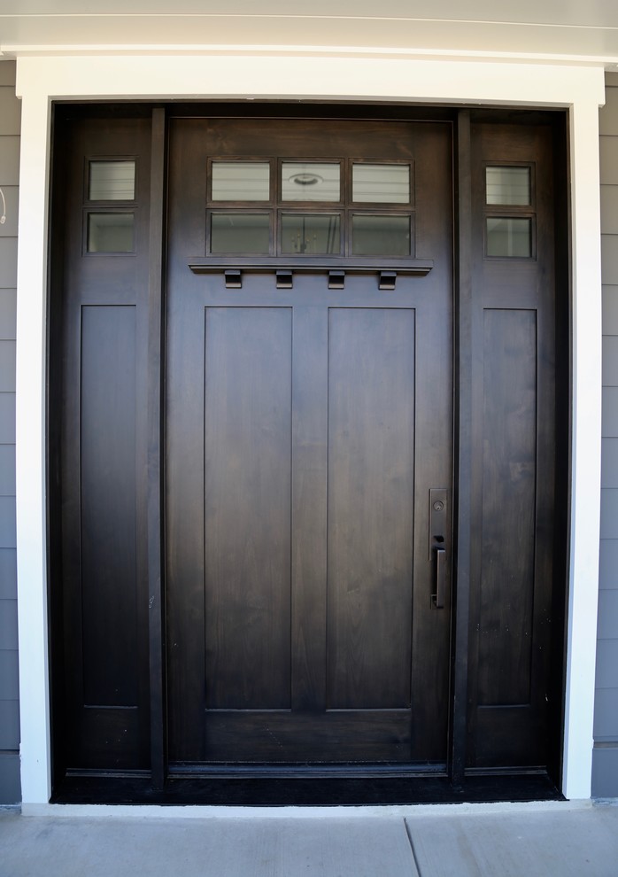 Imagen de distribuidor de estilo americano con paredes grises, suelo de madera oscura, puerta simple, puerta de madera oscura y suelo marrón