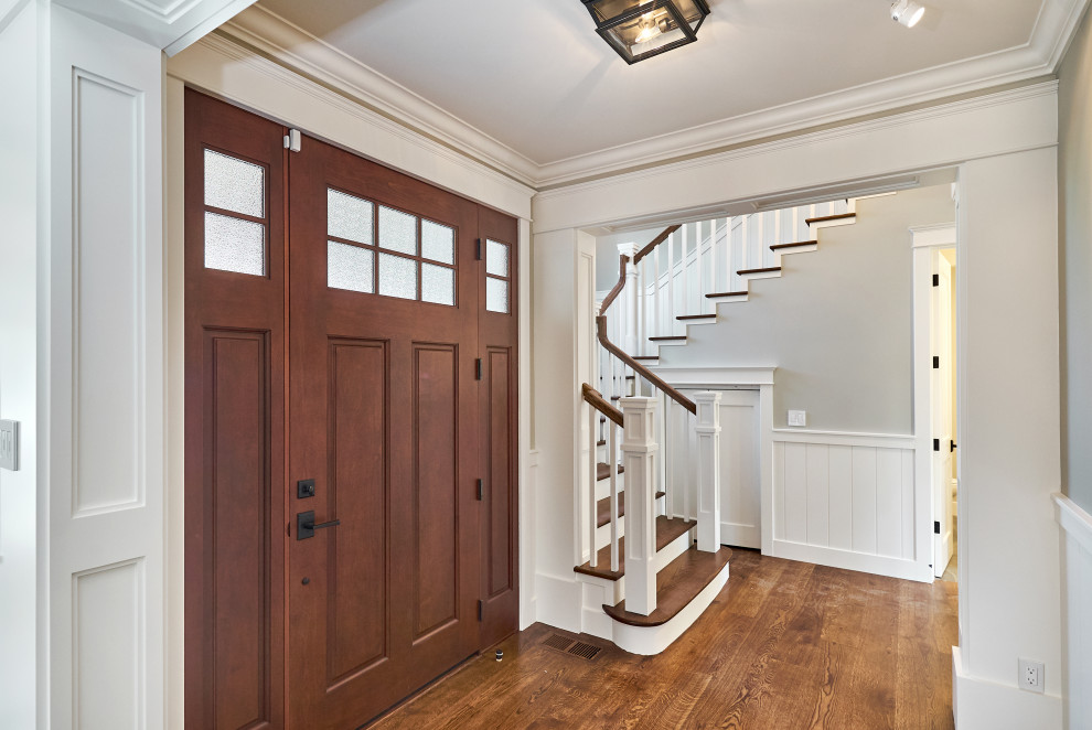 Стильный дизайн: входная дверь среднего размера в классическом стиле с серыми стенами, паркетным полом среднего тона, одностворчатой входной дверью, входной дверью из темного дерева и коричневым полом - последний тренд