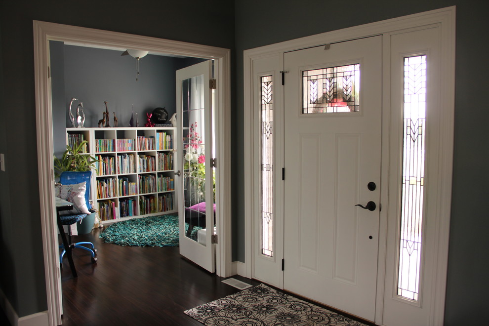 Traditional entrance in Chicago with blue walls, dark hardwood flooring and a single front door.