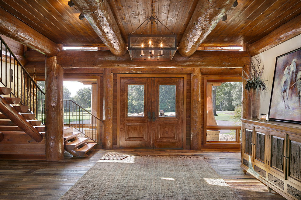 Esempio di un grande ingresso stile rurale con pavimento in legno massello medio, una porta a due ante e una porta in legno bruno