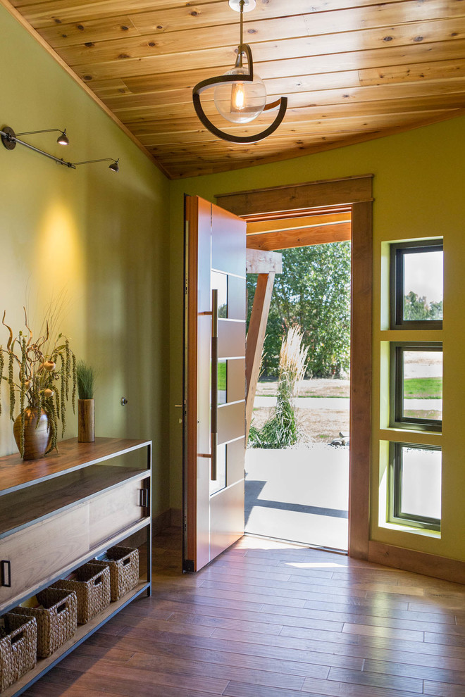 Foto di una grande porta d'ingresso minimalista con pareti verdi, pavimento in legno massello medio, una porta singola, una porta arancione e pavimento marrone