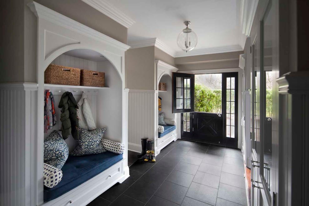 Example of a classic slate floor and black floor entryway design in New York with gray walls and a black front door