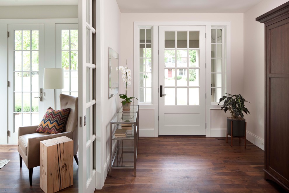 Inspiration for a classic vestibule in Minneapolis with white walls, a single front door, brown floors and feature lighting.