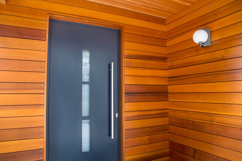 Ejemplo de puerta principal minimalista de tamaño medio con paredes blancas, suelo de madera oscura, puerta simple, puerta negra y suelo marrón