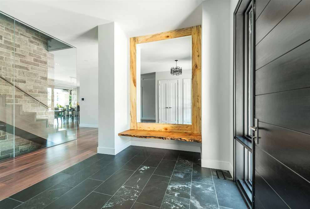 Inspiration for a large contemporary ceramic tile and black floor entryway remodel in Toronto with white walls and a dark wood front door