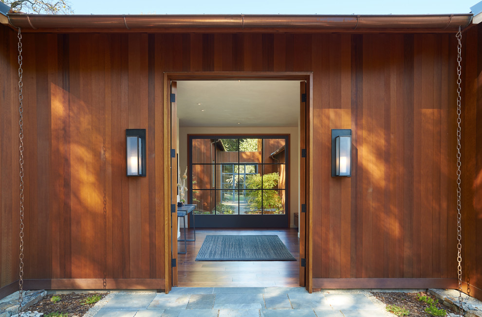 Foto di una porta d'ingresso country di medie dimensioni con una porta a due ante e una porta in legno bruno