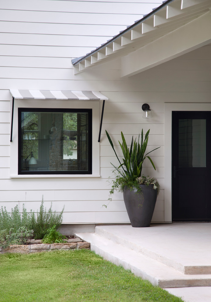 Idée de décoration pour une entrée champêtre avec une porte simple et une porte noire.