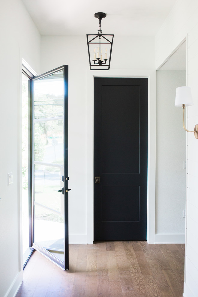 Esempio di un piccolo ingresso country con pareti bianche, pavimento in legno massello medio, una porta singola, una porta in vetro e pavimento marrone