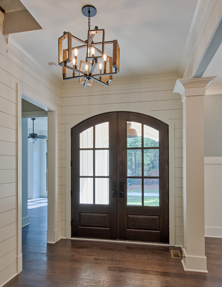 アトランタにある高級な広いカントリー風のおしゃれな玄関ドア (白い壁、濃色無垢フローリング、茶色いドア、茶色い床) の写真