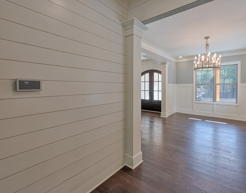 Example of a large country dark wood floor and brown floor entryway design in Atlanta with white walls and a brown front door
