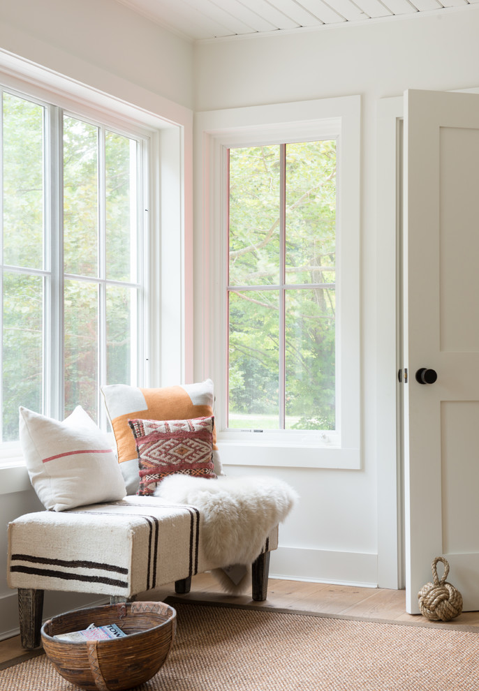 Small farmhouse light wood floor foyer photo in New York with white walls and a white front door