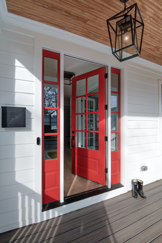 Immagine di un grande ingresso country con parquet chiaro, una porta singola, una porta rossa e pannellatura