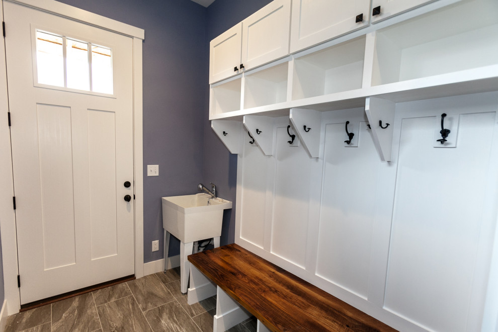 Inspiration for a small cottage porcelain tile and brown floor mudroom remodel in Salt Lake City with purple walls