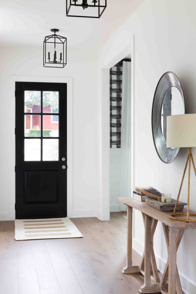 Mittelgroßer Country Eingang mit Korridor, weißer Wandfarbe, braunem Holzboden, Einzeltür, schwarzer Haustür und beigem Boden in Austin