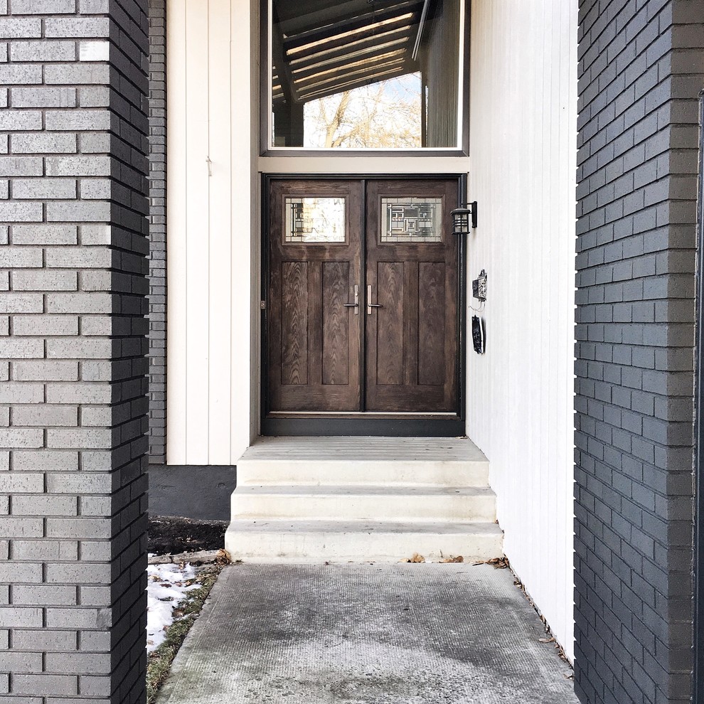 Diseño de puerta principal de estilo de casa de campo de tamaño medio con suelo de cemento, puerta doble, puerta de madera oscura y suelo gris