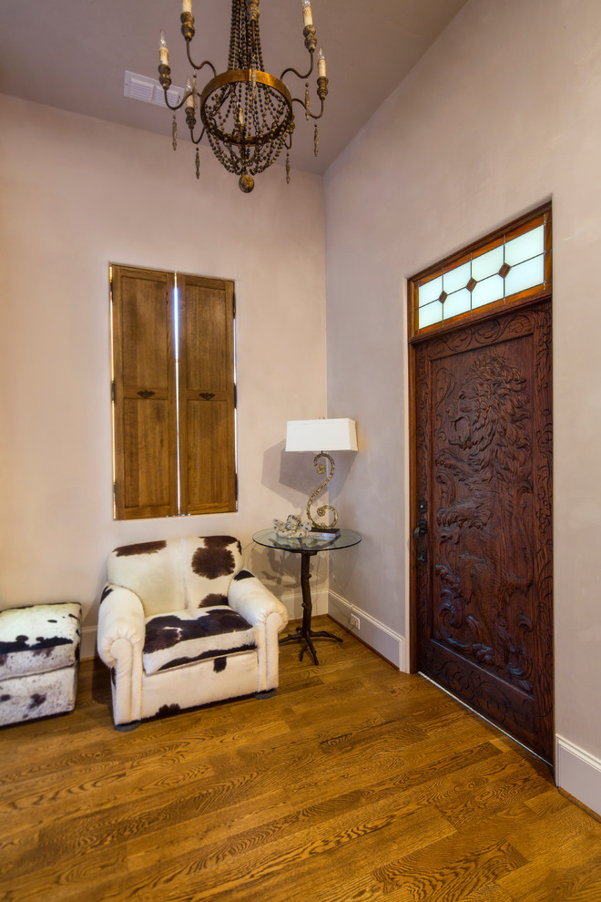ダラスにある高級な中くらいなカントリー風のおしゃれな玄関ロビー (白い壁、無垢フローリング、濃色木目調のドア) の写真